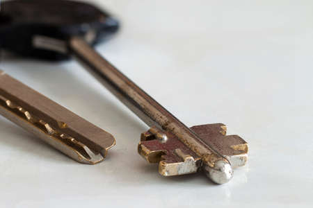 Silver key against white background close-up.の写真素材