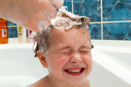 Mom's hands washing little girly's head in the bathroom. The symbol of purity and hygiene education.