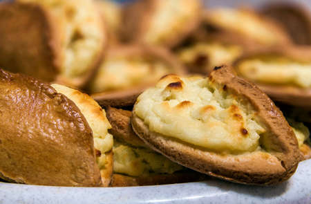 Puff pastry with cheese on a wooden background. Homemade baking pies.の写真素材