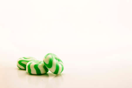 Green candies with stripes on white backgroundの写真素材
