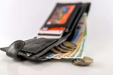 Leather men's open wallet with euro banknotes bills, coins and credit card inside isolated on white...