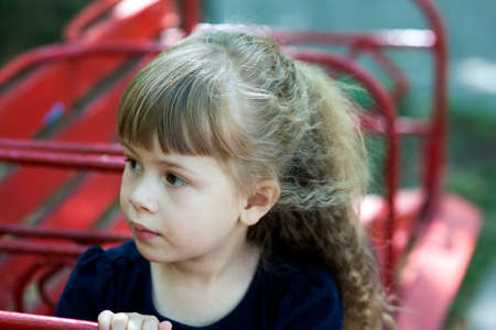 Little girl in an urban setting smiles at the camera. Portrait of happy, positive, smiling, playful  caucasian girl with beautilul hair.の写真素材