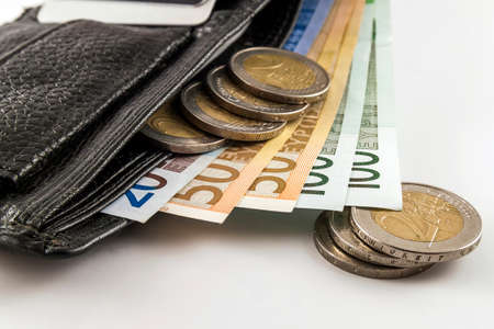 Leather men's open wallet with euro banknotes bills, coins and credit card inside isolated on white background.の写真素材