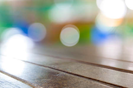 Old vintage grungy brown wooden tabletop boards with blurred restaurant bar cafe light color background:grunge aged wood with blurry warm cream light bokeh backdropの写真素材