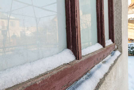 A view of brown old snow covered window.の写真素材