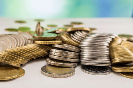 Growing coins stacks with green and blue sparkling bokeh background. Financial growth, saving money,...