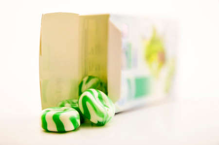 Green candies with stripes on white background