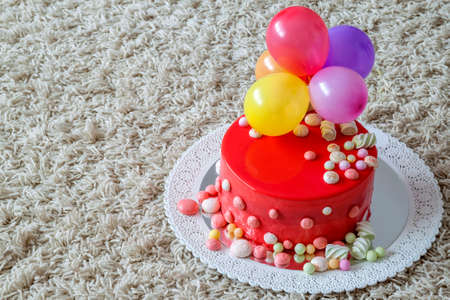 Homemade red birthday cake with air baloonsの写真素材