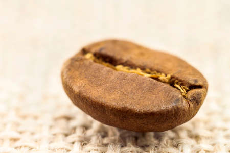 Coffee bean extreme close-up macro ob burlap sackcloth background.の写真素材