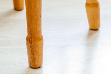 Close up of yellow wooden legs of a chairの写真素材