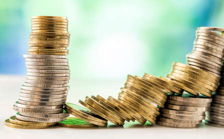 Growing coins stacks with green and blue sparkling bokeh background. Financial growth, saving money, business finance wealth and success concept.の写真素材