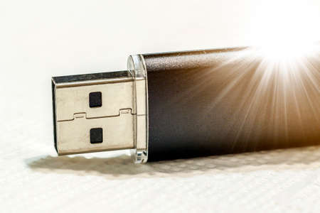 Black usb flash drive isolated on white background with sun beams soft lightの写真素材