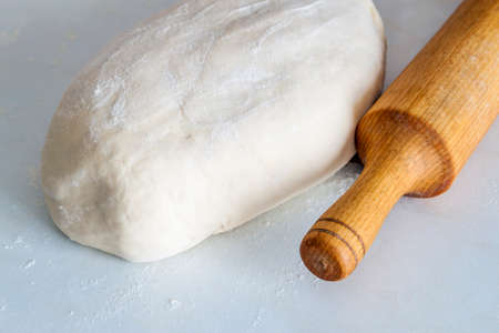 Dough bread, pizza or pie recipe homemade rolling pin preparation on kitchen table. Working with pastry or bakery cooking.の写真素材
