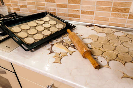 Rolling pin with dough on kitchen table. Preparing dough round tortillas for cookings to be baked.の写真素材