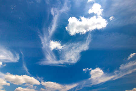 Dramatic blue sky with puffy white clouds in bright clear sunny dayの写真素材