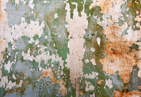 Green metal plate with cracked paint and big paint spots because of time as background, metal wall...