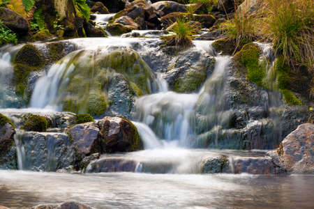 Small Waterfall in park with beautifull smooth water. Little waterfall in mountain forest with silky foaming water.の写真素材