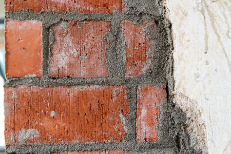 Close up of bricklaying industrial installing bricks on construction site wallの写真素材