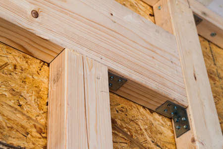 Construction of wood frame walls of a new country house site. Unfinished construction work inside.