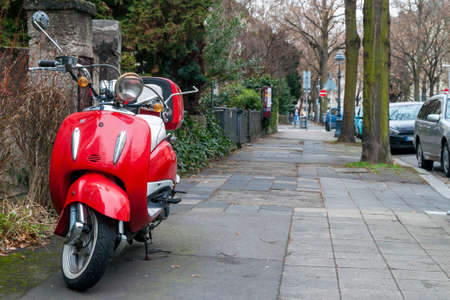 Red vintage motorbike parked on street sidewalkのeditorial素材