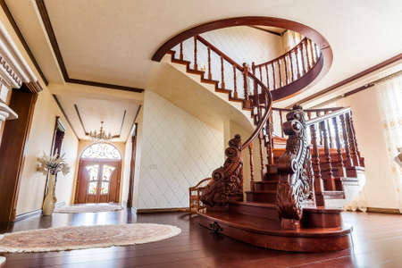 Modern architecture interior with classic elegant luxury hallway with curved glossy wooden staps stairs in modern storey houseのeditorial素材