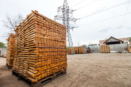 Stack of new wooden boards and studs at the lumber yard. Wooden plates on piles for furniture materialsの写真素材