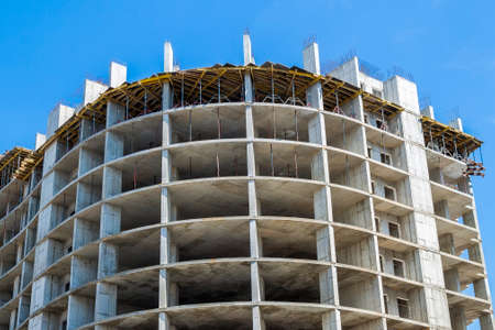 Modern building under construction against blue sky. Construction work siteの写真素材