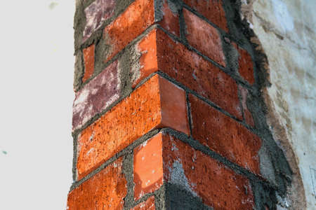 Close up of bricklaying industrial installing bricks on construction site wallの写真素材