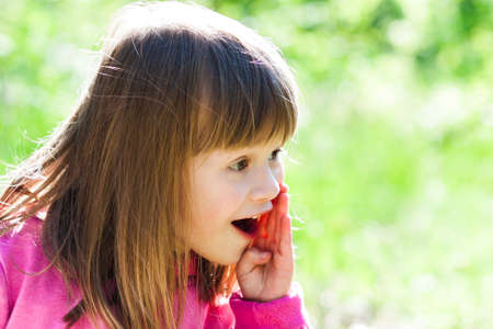 Close-up portrait of a little pretty girl with shouting face expressionの写真素材