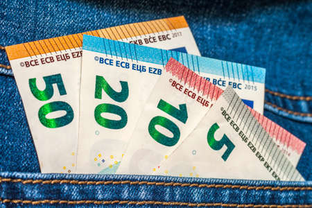 Euro money banknotes in a pocket of blue jeans close upの写真素材