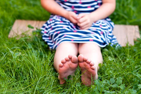 Close up of feet of little girl on green grassの写真素材