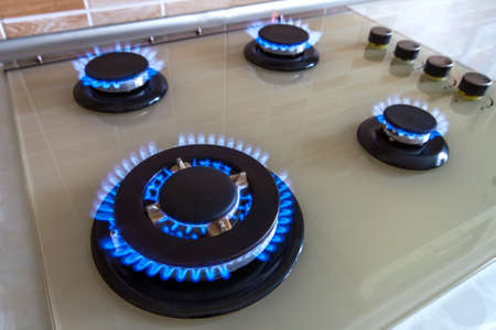 Closeup shot of blue fire from domestic kitchen stove. Gas cooker with burning flames propane gas.
