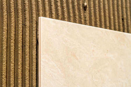 Ceramic tiles on a wall installation. Home improvement and renovation.