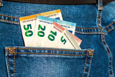Euro money banknotes in a pocket of blue jeans close up