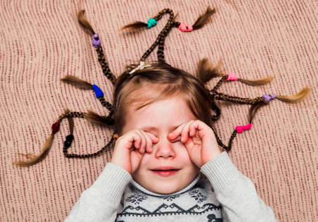 Close-up portrait of little child girl with hair braidsの写真素材