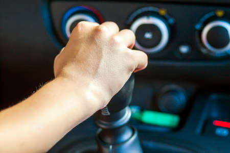 Driver hand shifting gear shift knob manually, selective focus