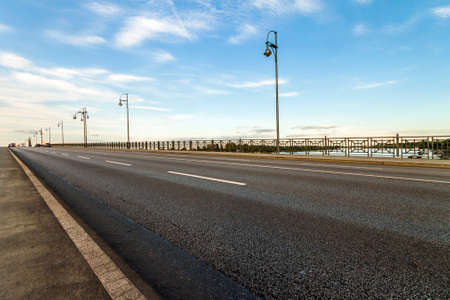 Empty asphalt road on a bridge over river