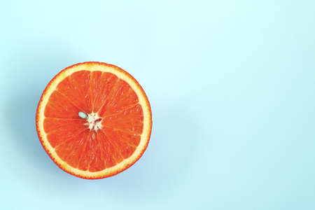 Half of ripe juicy orange on light blue backgroundの写真素材