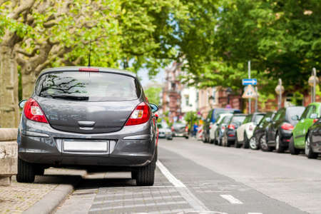 Rows of cars parked on the roadside in residential districtの写真素材