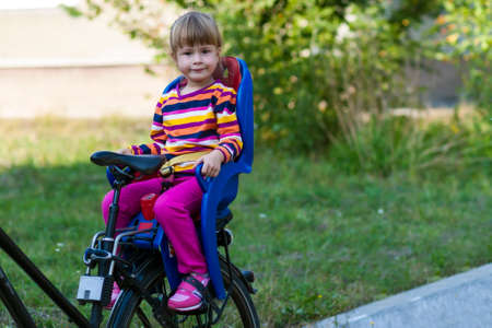 Little girl sitting in bicycle seatの写真素材