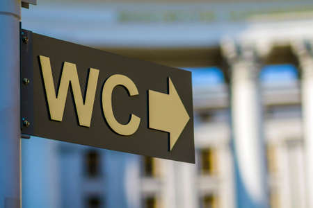 Toilet sign and direction outdoors-  public restroom concept on urban background