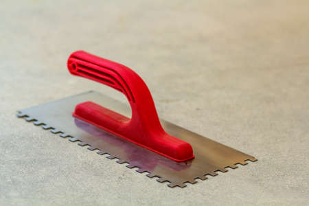 Construction notched trowel is a tool for tiles installation workの写真素材