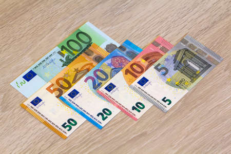 Different euro money banknotes on wooden backgroundの写真素材