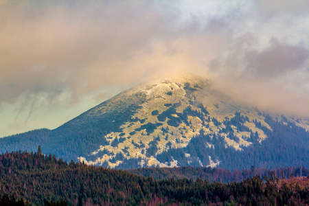 Big mountain with foggy clouds over the summit