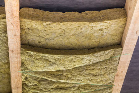 Thermal insulation mineral rock wool installation at the new building attic ceilingの写真素材