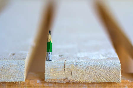 Wooden boards table top with one small pencilの写真素材