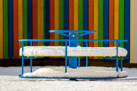 Playground in kindergarten for children in winter with snow covered swingsの写真素材