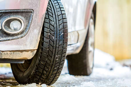 Close-up of car wheel in winter tire on snowy road
