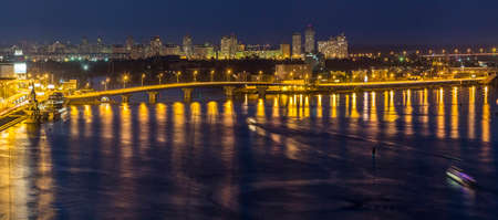 Kyiv (Kiev) city, the capital of Ukraine at night beside the Dnipro (Dniepr) river with reflection...