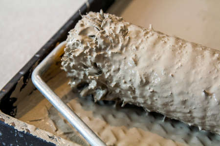 Paint roller in paint tray with grey color in the trayの写真素材